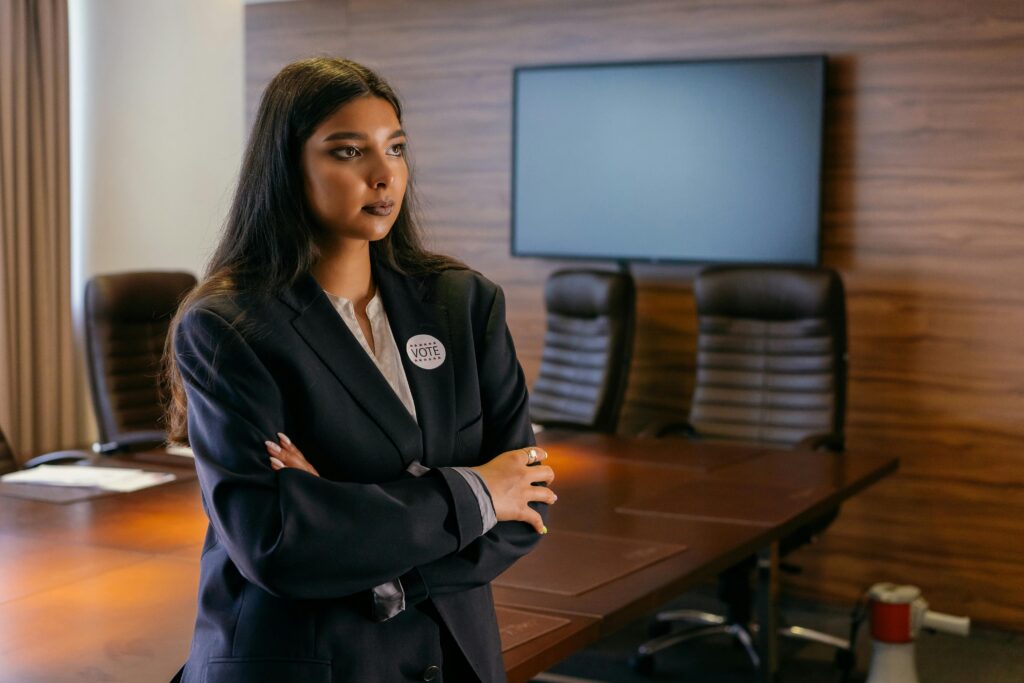 A team leader standing next to a wooden desk.